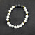 Howlite and lava stone bracelet with white marbled beads and black porous lava stones shown on black background.