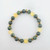 Jade and citrine gemstone bead bracelet laid flat showing alternating green jade and yellow citrine beads with gold accent spacers.