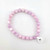 Single kunzite 8mm beaded bracelet photographed from above on white background