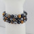 Close-up of tiger eye, obsidian, and hematite beads showing polished 8mm gemstone bracelet.