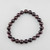 Garnet gemstone 10mm bead bracelet laid flat on white background