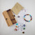 Chakra bracelet with diffuser beads displayed outside bamboo box with pouch and stones