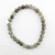 Overhead view of a single strand Labradorite stretch bracelet laid flat on a white background.