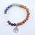 A single chakra alignment bracelet showcasing a rainbow sequence of polished natural stones on a white background.