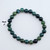 A single Moss Agate stretch bracelet featuring 8mm polished green and translucent beads with natural organic patterns on a white background