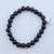 A single Black Onyx stretch bracelet with polished 8mm black beads on a white background.