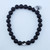 A single Lava Stone stretch bracelet featuring 8mm porous black volcanic beads on a neutral background.