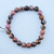 A single Rhodonite stretch bracelet featuring 8mm polished pink beads with natural black marbled veins on a white background.