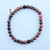 A single Rhodonite stretch bracelet featuring 6mm polished pink beads with natural black marbled veins on a white background.
