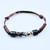 An adjustable brown leather bracelet featuring a glass vial center filled with floating Australian Opals in glycerin.