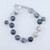 Picture Jasper bead bracelet featuring tan and cream stones with unique organic black landscape-like banding on a silver-grey cord.