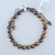 Tiger’s Eye bead bracelet featuring polished golden-brown stones with natural chatoyant bands on a chocolate brown adjustable cord.