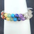 Close-up of clear crystal chakra bracelet showing the light-reflecting properties of natural quartz beads.