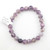 A single Unicorn Stone bead bracelet laid flat, showcasing the soft purple and grey mineral variations.