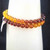 Close-up of Natural Amber beads on a stretch cord highlighting the internal clarity and warm, golden-brown tones.