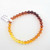 A single strand of polished Amber beads laid flat, showcasing the organic variation in color and translucent quality.