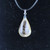 Close-up of a Rutilated Quartz pendant showing clear transparency and unique internal golden rutile patterns against a dark background.