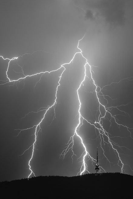 Lightning strikes behind Telstra Tower in a black and white image