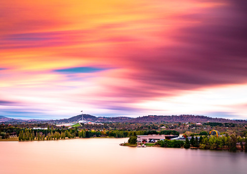 Sunset over APH and the NMA with streaky clouds and smooth water of Lake Burley Griffin