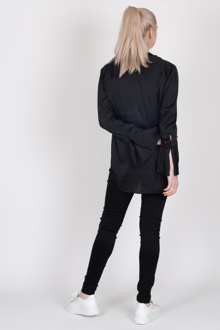 Tall woman in back profile modelling the Storm black Paloma Shirt untucked with Storm Tuxedo Pants
