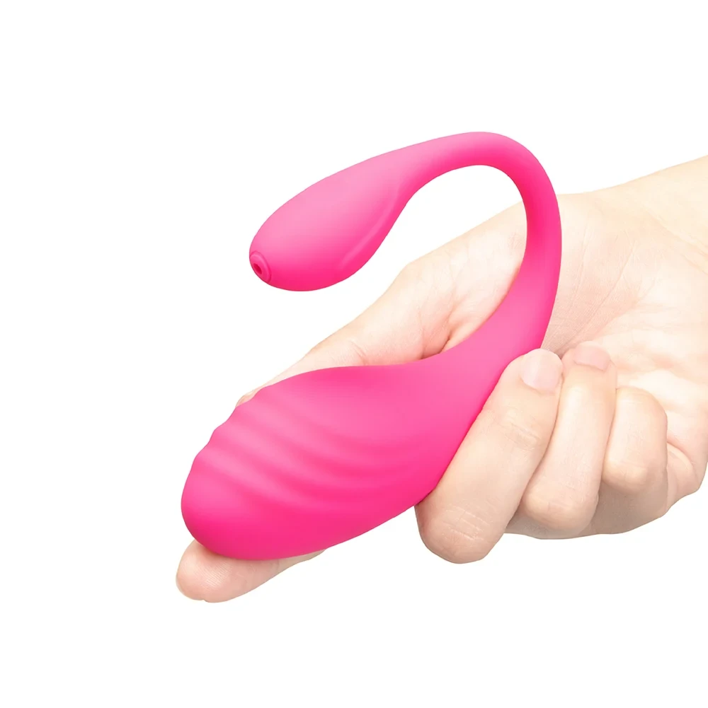 Together Ménage à Trois hot pink vibrating egg held in a hand to show compact wearable size and ribbed surface.