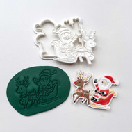 Decorated Santa and reindeer fondant cookie with gold sleigh